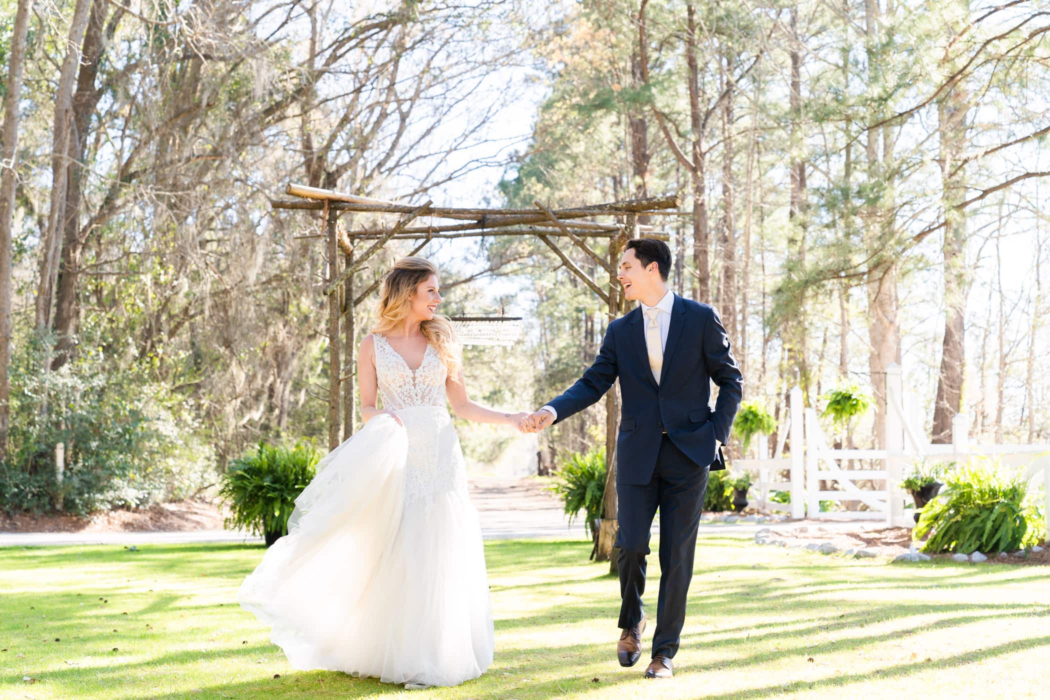 bride and groom holding hands and walking outdoors
