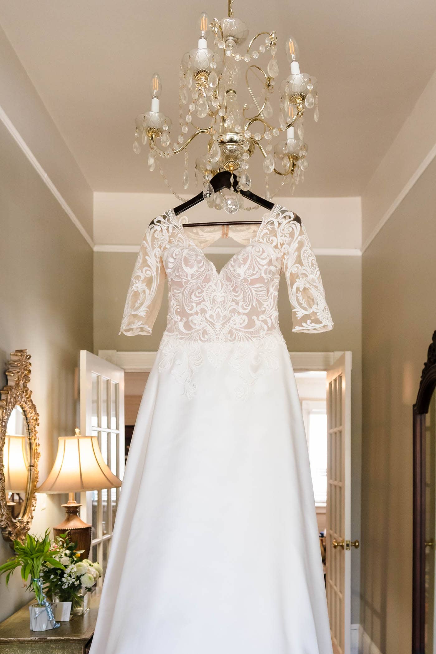 Wedding Dress hanging on Chandelier in cottage at The Beaufort Inn by Wedding Photographer Susan DeLoach Photography