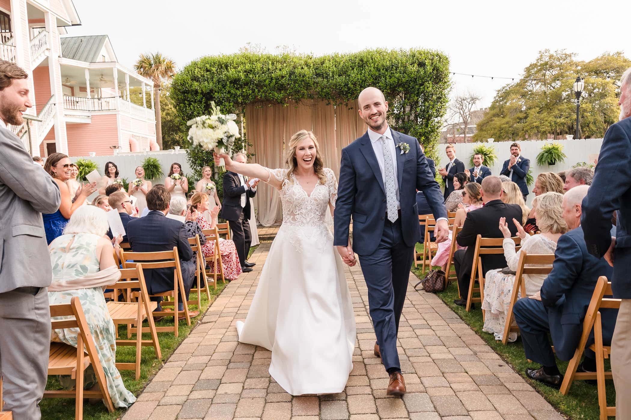 Joyful Bride and Groom walking down the isle as Husband and wife in the Tabby Garden at the Beaufort Inn by Wedding Photographer Susan DeLoach Photography