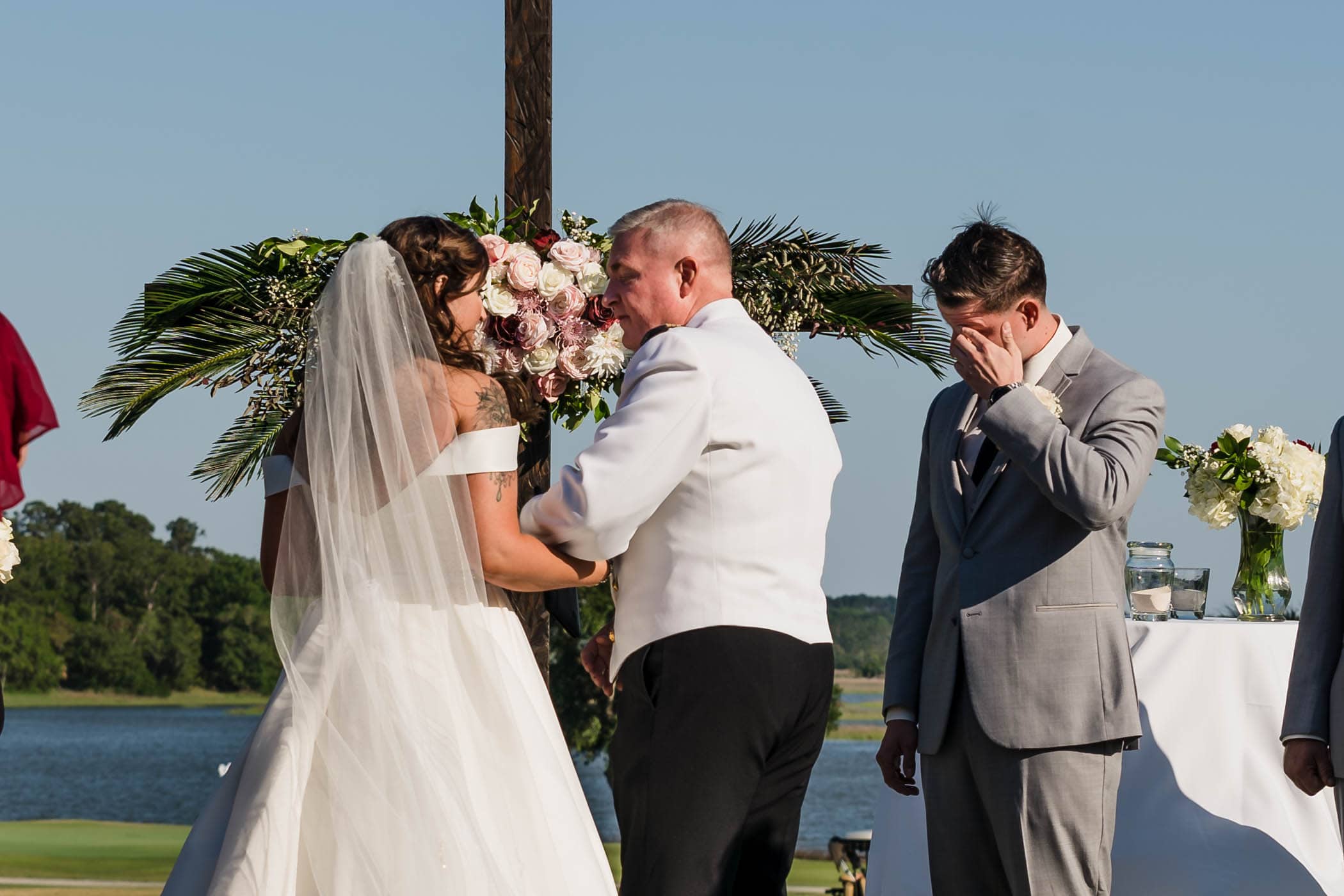 Groom wiping tears from his eyes as bride walks up with her father by Susan DeLoach Photography SC wedding photographers