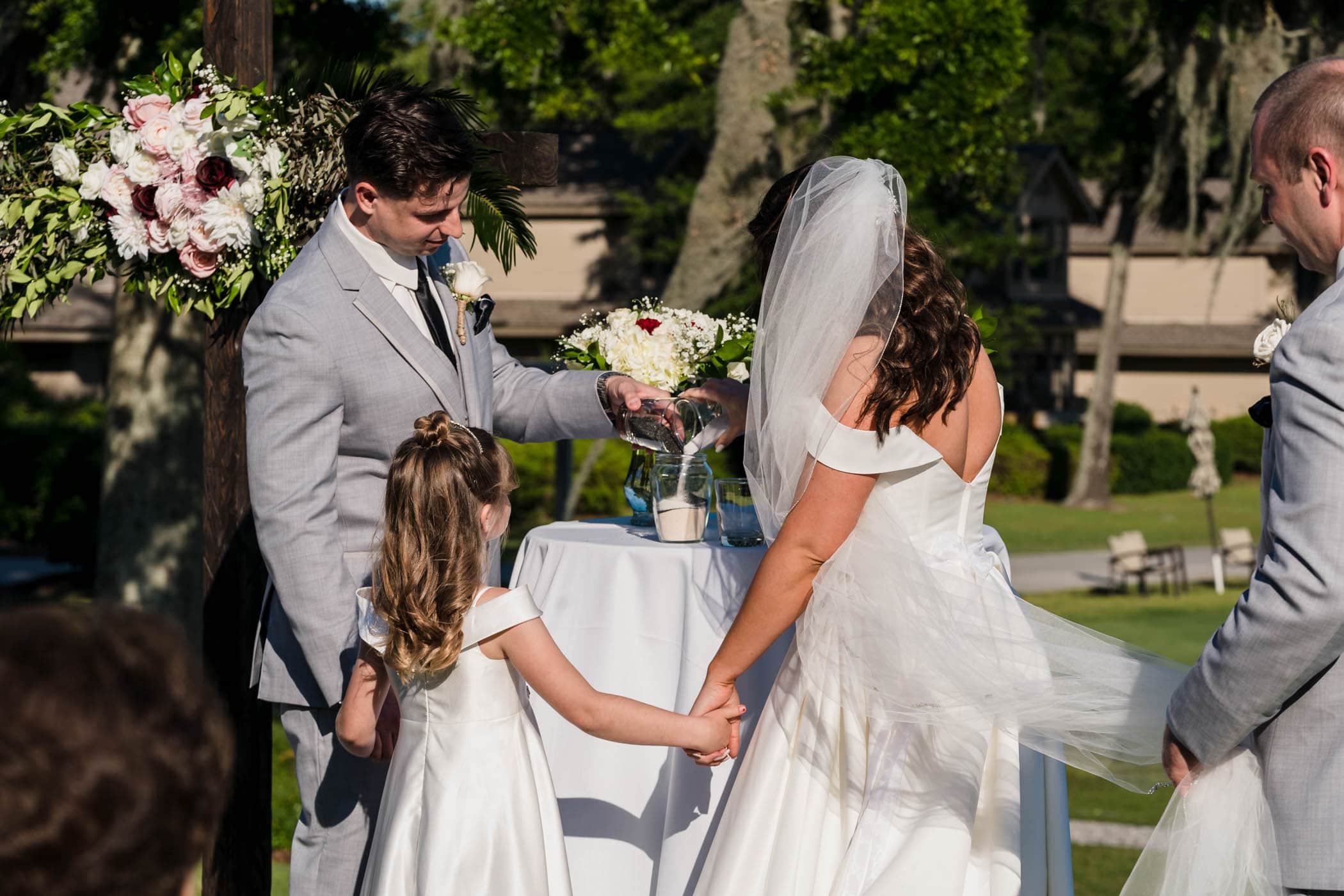 Bride, groom and daughter during sand ceremony at wedding Dataw Island Club House by Susan DeLoach Photography SC wedding photographers