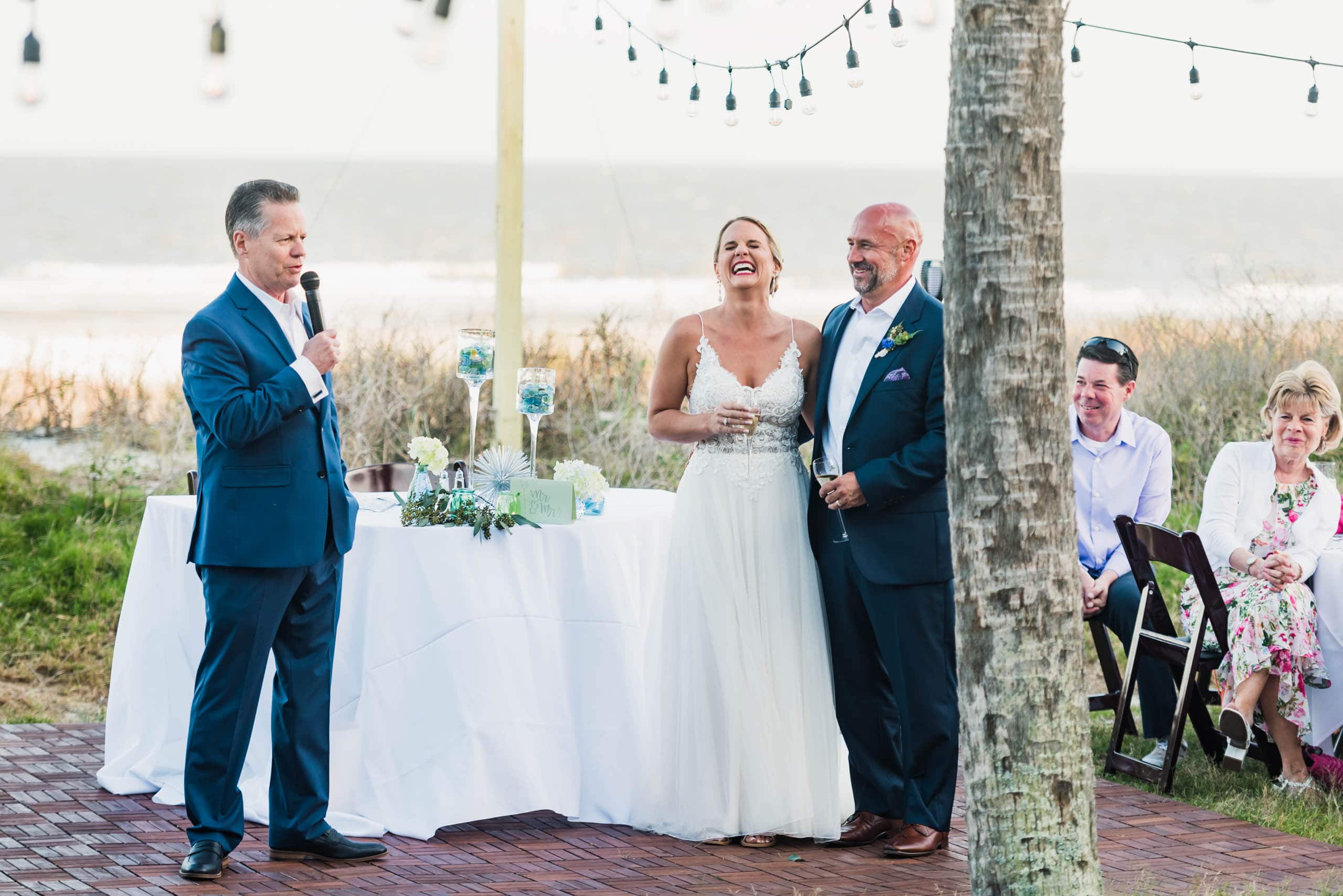 Bride and Groom laughing during speech given by the father of the bride at a beach wedding on Fripp Island By Susan DeLoach Photography SC Wedding Photographer