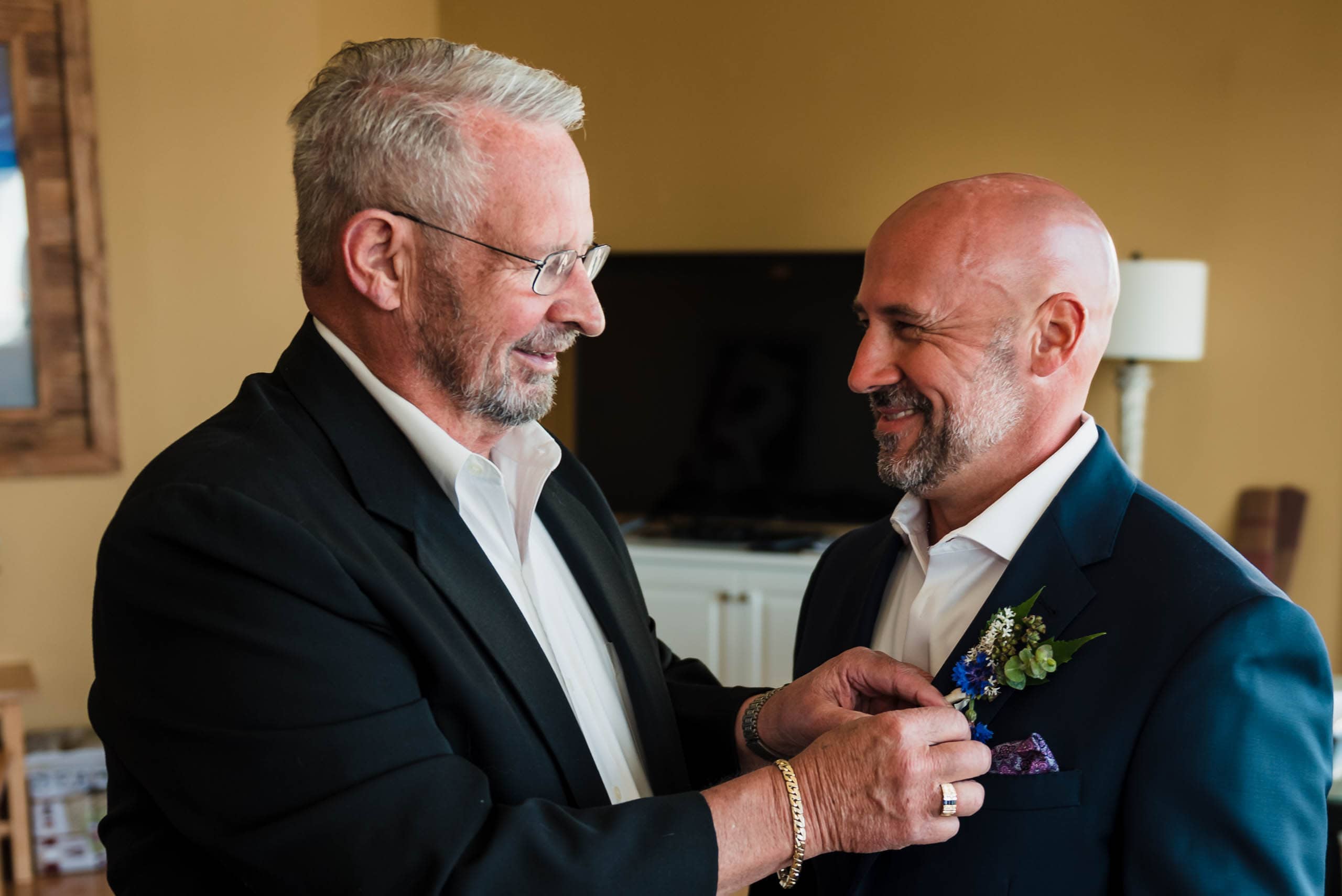 father of the groom pinning boutonniere on groom at Fripp Island Beach Wedding by Susan DeLoach Photography SC wedding photographer