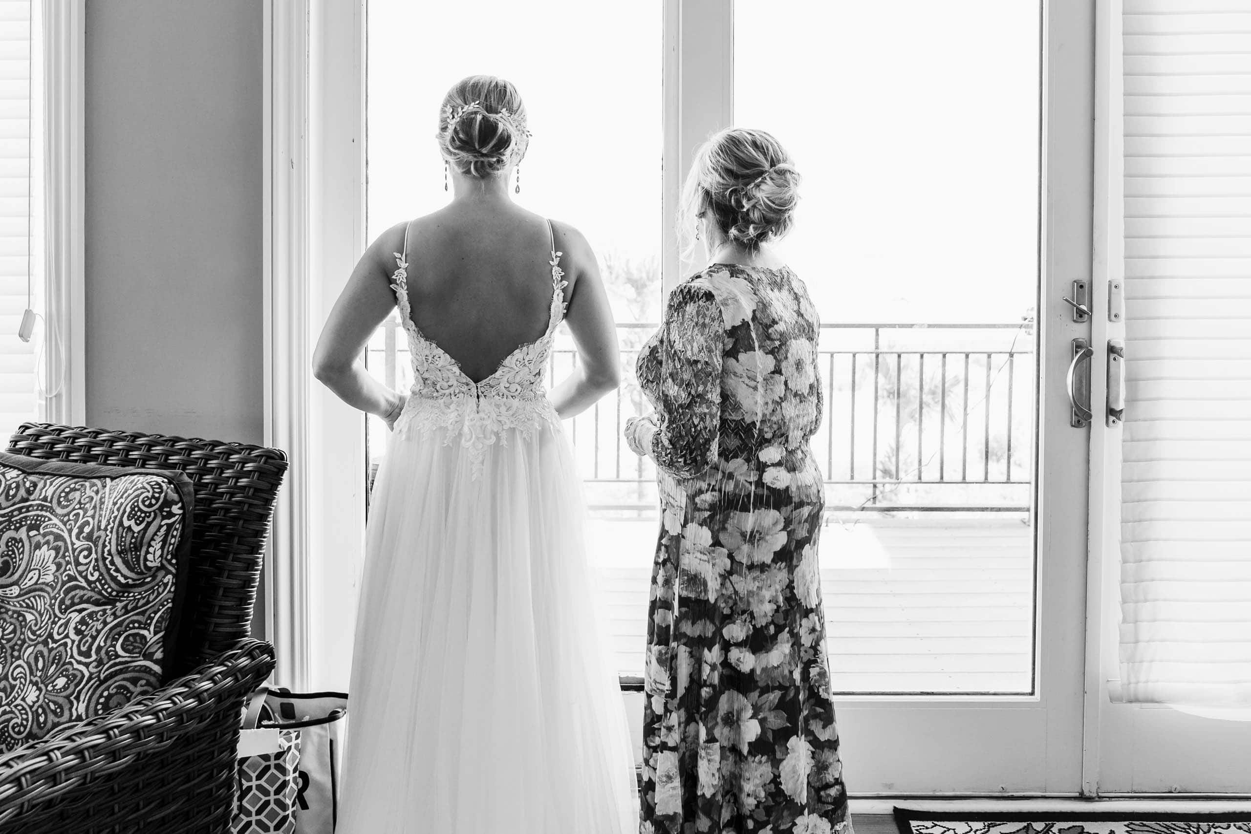 Bride in wedding dress looking out of a window at beach ceremony site on Fripp Island by Susan DeLoach Photography SC wedding Photographer